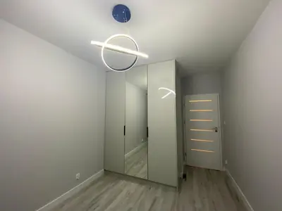 a hallway with a mirror and a blue clock on the ceiling at Pure Vista Apartment in Kraków
