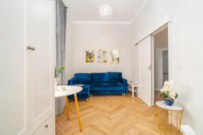 a living room with a blue couch and a window at Art Deco Elegance in Kraków