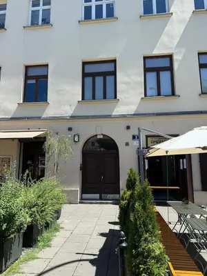 a building with a black door and a patio at Househost Apartment Plac Wolnica 9 in Kraków