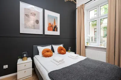 a bedroom with a bed with orange pillows on it at Historic Hideaway - Podgórze - by Upstairs in Kraków