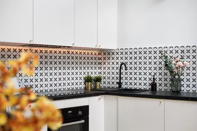 a kitchen with black counter tops and black and white tiles at Historic Hideaway - Podgórze - by Upstairs in Kraków