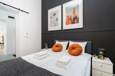 a bedroom with a white bed with orange pillows at Historic Hideaway - Podgórze - by Upstairs in Kraków