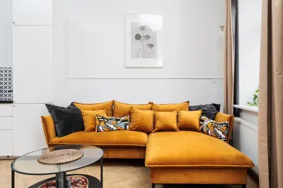 a living room with a yellow couch and a table at Historic Hideaway - Podgórze - by Upstairs in Kraków