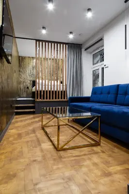 a living room with a blue couch and a glass coffee table at Househost Apartment Wielopole 10 in Kraków