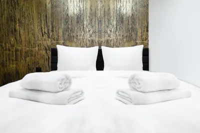a bed with two statues of heads on it at Househost Apartment Wielopole 10 in Kraków