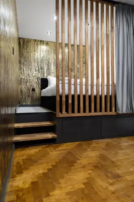 a bedroom with a bed and a wooden wall at Househost Apartment Wielopole 10 in Kraków