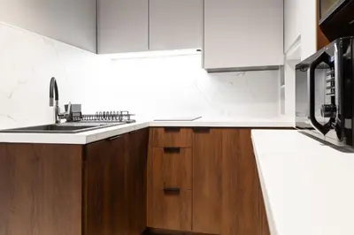 a kitchen with wooden cabinets and a sink at Househost Apartment Wielopole 10 in Kraków