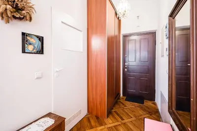 a hallway with a wooden door and wooden floors at Old City Old Style Studio in Kraków