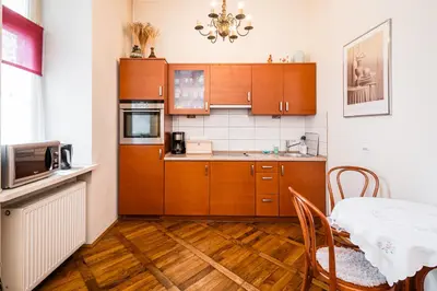 a kitchen with wooden cabinets and a table and a table and chairs at Old City Old Style Studio in Kraków