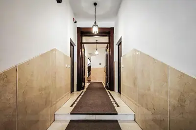 a hallway with white walls and a long hallway with wooden doors at Old City Old Style Studio in Kraków