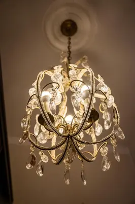 a gold chandelier hanging from a ceiling at Old City Old Style Studio in Kraków
