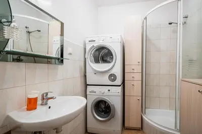 a bathroom with a washing machine and a sink at Old City Old Style Studio in Kraków