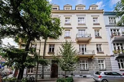 a large white building with a car parked in front of it at Old City Old Style Studio in Kraków
