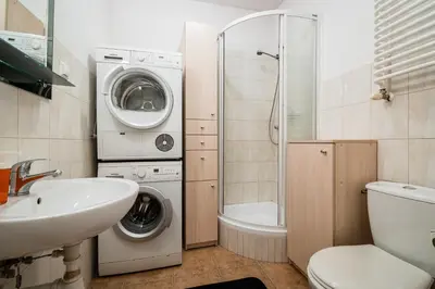 a bathroom with a toilet sink and a washing machine at Old City Old Style Studio in Kraków