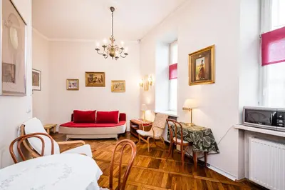 a living room with white walls and a red couch at Old City Old Style Studio in Kraków