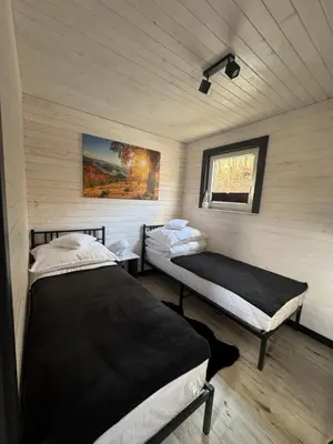 a bedroom with two beds and a window at Zacisze Mogielicy-Domki w Beskidzie Wyspowym in Półrzeczki