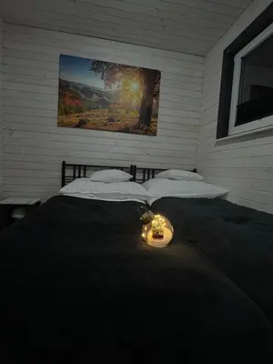 a bedroom with two beds with a candle on it at Zacisze Mogielicy-Domki w Beskidzie Wyspowym in Półrzeczki