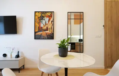 a dining room with a glass table and a potted plant at Apartamenty Złota Brama in Kraków