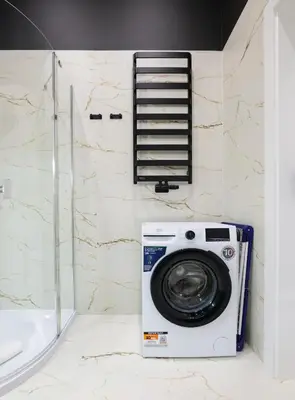 a washing machine in a bathroom next to a shower at Apartamenty Złota Brama in Kraków