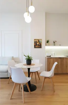 a living room with a table and two white chairs at Apartamenty Złota Brama in Kraków