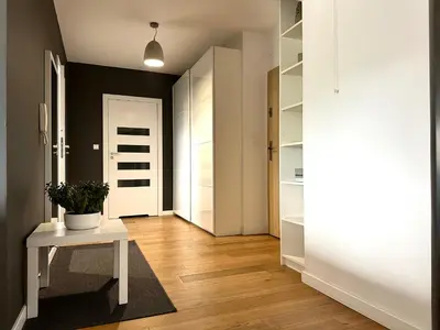 a hallway with a white table and a white door at Masarska Apartment - Self Check-In 20h - Parking&Lift in Kraków