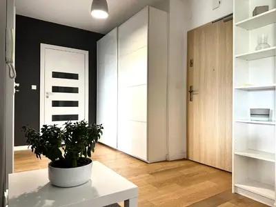a living room with a potted plant on a white table at Masarska Apartment - Self Check-In 20h - Parking&Lift in Kraków