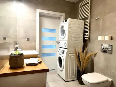 a bathroom with a washing machine and a washer and dryer at Masarska Apartment - Self Check-In 20h - Parking&Lift in Kraków