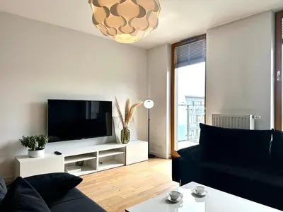 a living room with a black couch and a flat screen tv at Masarska Apartment - Self Check-In 20h - Parking&Lift in Kraków
