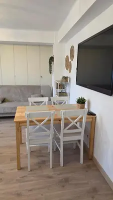 a living room with a table and chairs and a flat screen tv at Apartament Boho 23 in Kraków