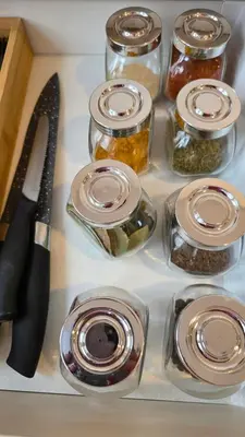 a counter with a knife and jars of pickles at Apartament Boho 23 in Kraków