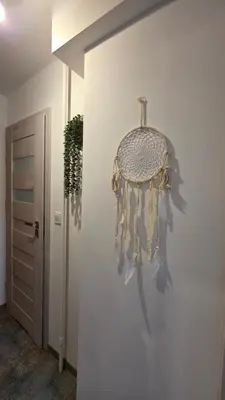 a dream catcher hanging on a wall in a hallway at Apartament Boho 23 in Kraków