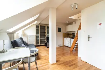 a living room with a table and chairs and a kitchen at RentPlanet - Apartament Garbarska in Kraków
