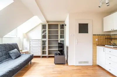 a living room with a couch and a kitchen at RentPlanet - Apartament Garbarska in Kraków
