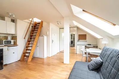 a kitchen and a living room with a couch and a table at RentPlanet - Apartament Garbarska in Kraków