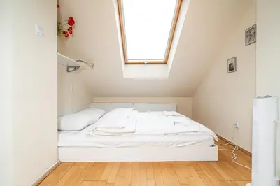 a bed in a small room with a window at RentPlanet - Apartament Garbarska in Kraków
