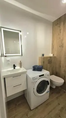 a bathroom with a washing machine and a toilet at Apartament na Wzgórzu 2 in Bochnia