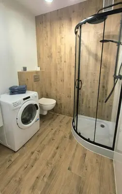 a bathroom with a washing machine and a toilet at Apartament na Wzgórzu 2 in Bochnia