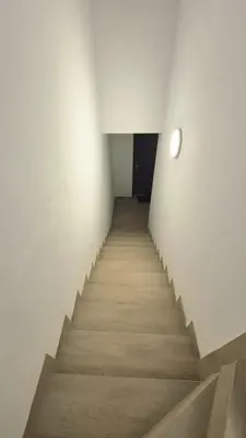 a staircase in a room with white walls and wooden floors at Apartament na Wzgórzu 2 in Bochnia
