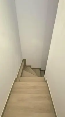 a staircase in a room with white walls and wooden floors at Apartament na Wzgórzu 2 in Bochnia