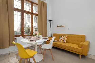 a living room with a couch and a table and chairs at Charming Apartment with Mezzanine near Old Town in Cracow by Noclegi Renters in Kraków