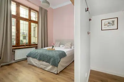 a bedroom with a bed and a window at Charming Apartment with Mezzanine near Old Town in Cracow by Noclegi Renters in Kraków