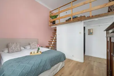 a bedroom with a bed and a spiral staircase at Charming Apartment with Mezzanine near Old Town in Cracow by Noclegi Renters in Kraków