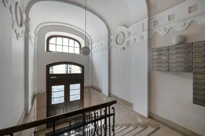 a hallway with a staircase in a building with a window at Charming Apartment with Mezzanine near Old Town in Cracow by Noclegi Renters in Kraków
