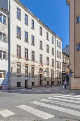 a large white building on the side of a street at Charming Apartment with Mezzanine near Old Town in Cracow by Noclegi Renters in Kraków