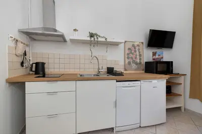 a kitchen with white cabinets and a sink at Charming Apartment with Mezzanine near Old Town in Cracow by Noclegi Renters in Kraków