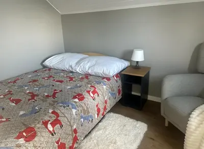 a small bedroom with a bed and a chair at Apartament Buldog in Zawoja