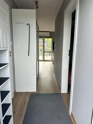 a hallway with white doors and a rug at Apartament Buldog in Zawoja