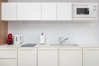 a white kitchen with a sink and a microwave at City of the Kings-Riverside K22M31 in Kraków