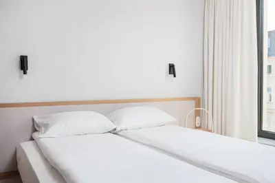 a bed with white sheets and pillows next to a window at City of the Kings-Riverside K22M31 in Kraków