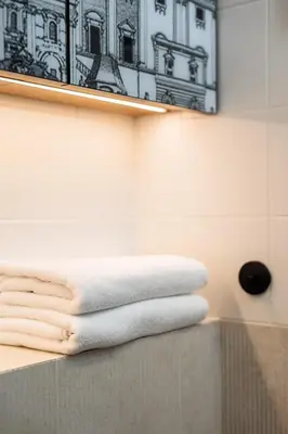a pile of towels sitting on a counter in a bathroom at City of the Kings-Riverside K22M31 in Kraków